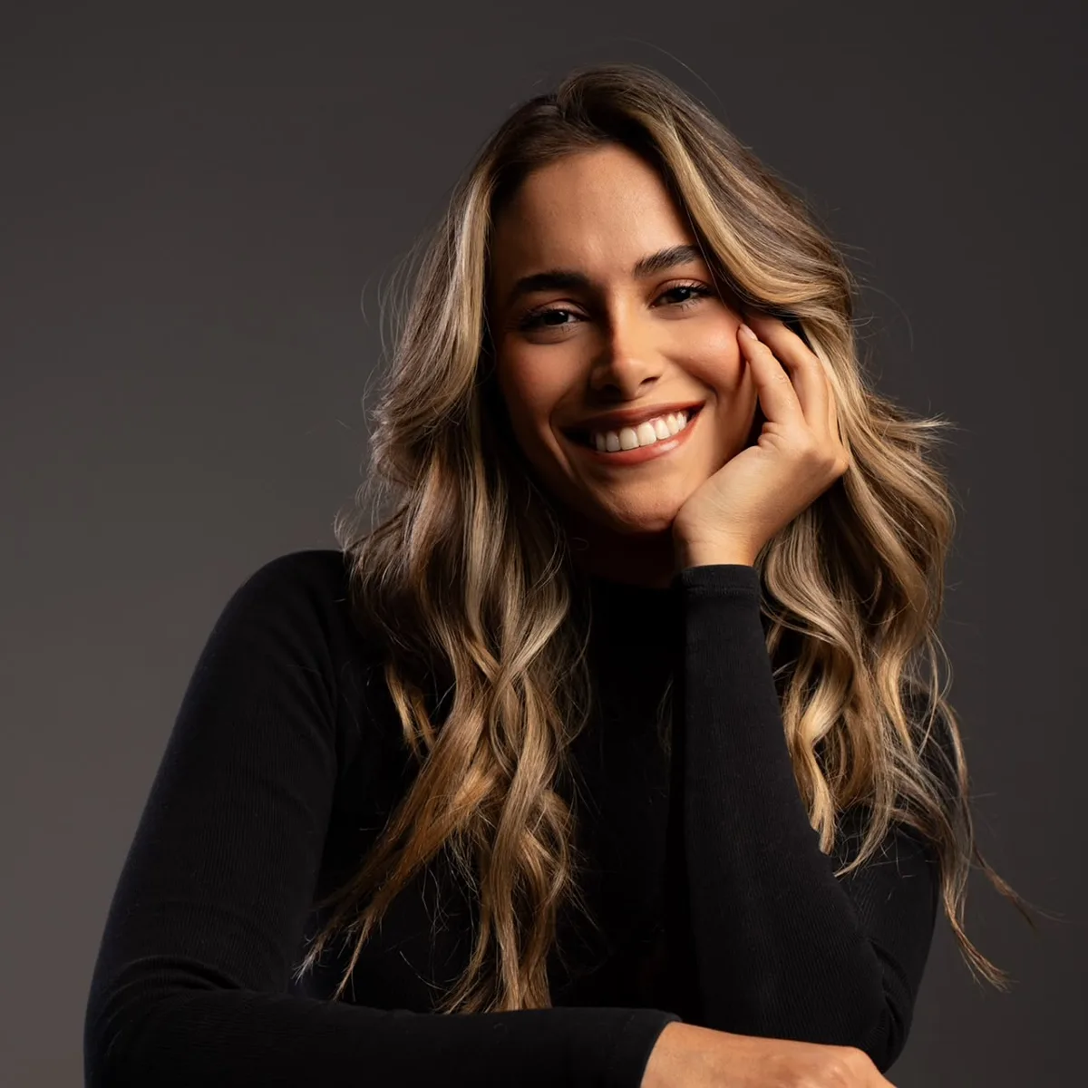 Sylvia Alondra sonriendo, retrato con suéter negro